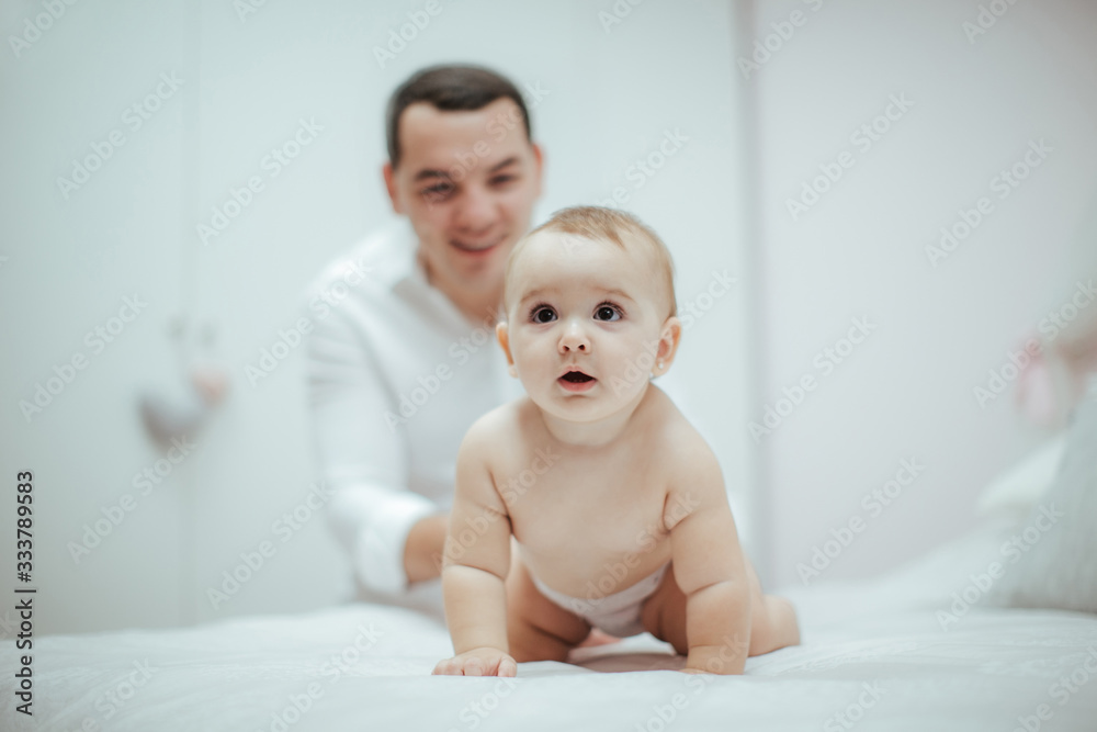 Smiling young couple playing with their beloved newborn baby girl on the bed Smiling young couple playing with their beloved newborn baby girl on the bed
