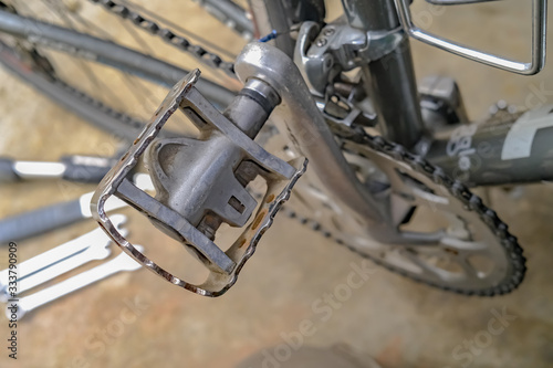 Bicycle maintenance - Close up of a pedal of a racing cycle with out of focus tools on the workshop floor