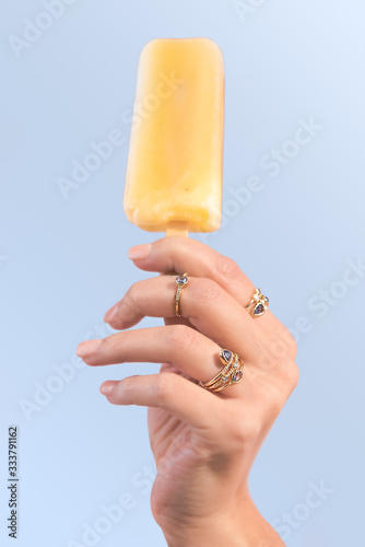 Hand holding popsicle with rings on