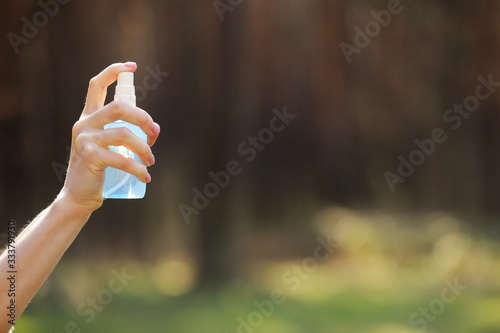 woman hand holding alcohol spray or anti bacteria spray outdoor to prevent spread of germs, bacteria and virus, quarantine time, focus on close up hands. coronavirus. copy space. selective focus © Andriy Medvediuk