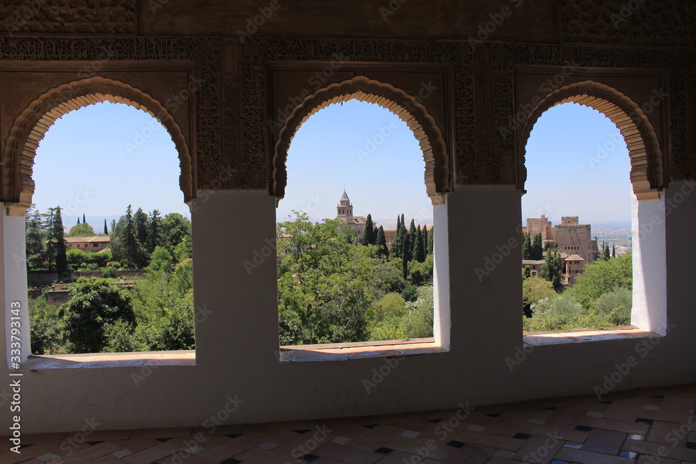 A view of Alhambra palace and fortress complex through a window at Generalife gardens in Granada, Andalusia, Spain.