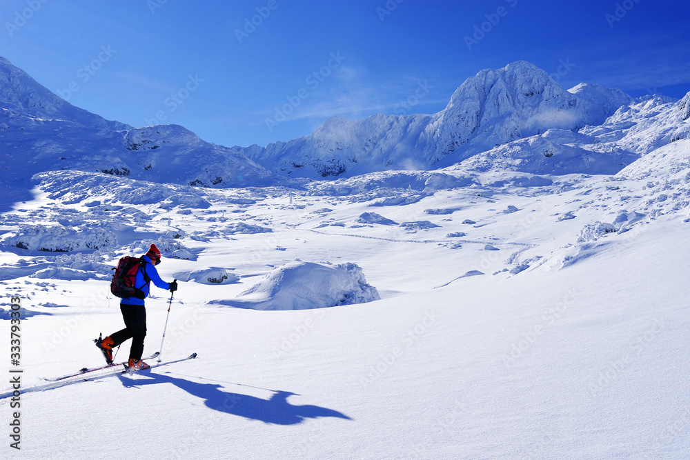 Ski touring in harsh winter conditions. Ski tourer sporting in in the mountains. Winter alpine landscape