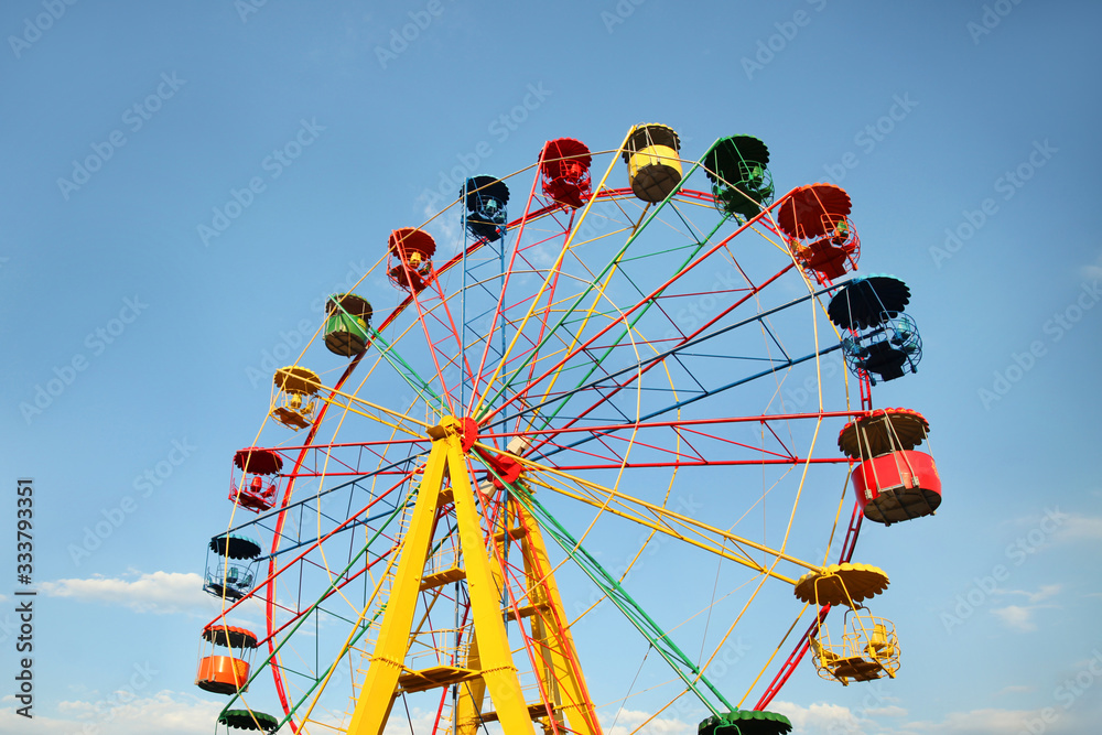 Huge colorful Ferris wheel without people against the blue sky