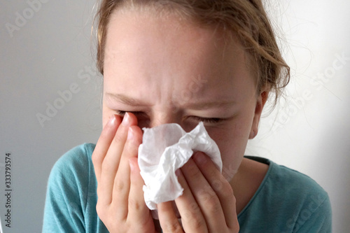  girl sneezes into a napkin
