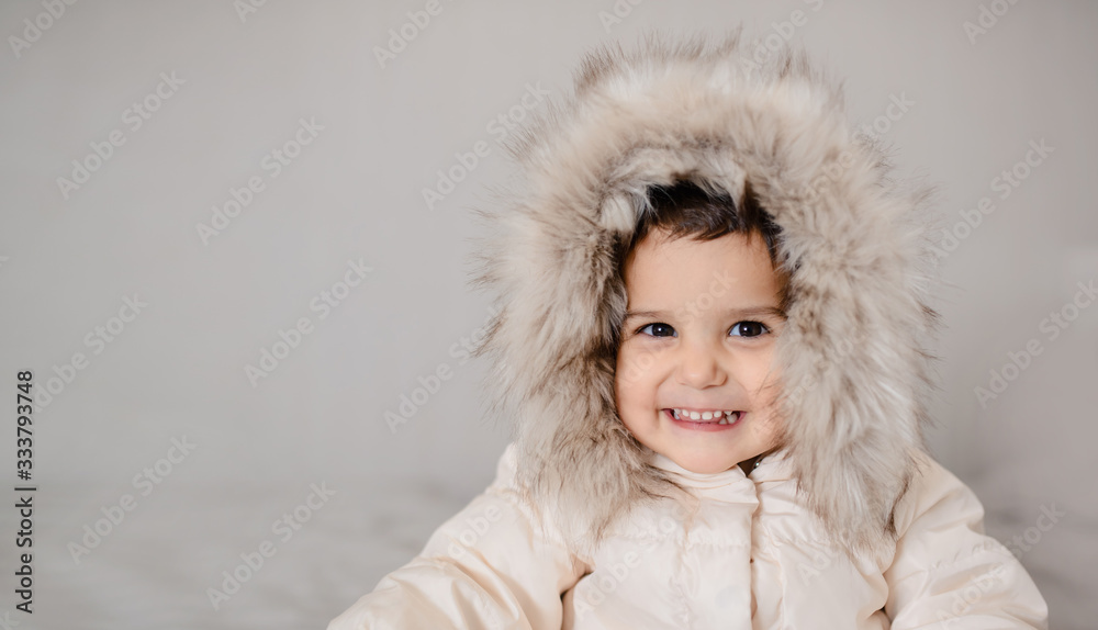 Happy little child girl in white down jacket Happy little child girl in white down jacket
