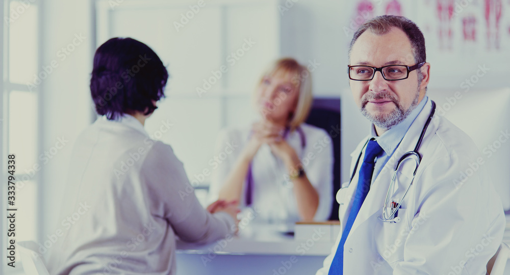 Fototapeta premium Portrait of senior doctor in office sitting at the desk