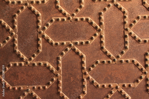 Metal door pattern of Nasrid Palaces (Palacios Nazaries) at the historical Alhambra Palace complex in Granada, Andalusia, Spain.