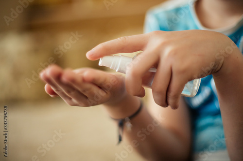 sanitizer in hands of child. Hand treatment is disinfection tool. Destroying viruses from surface of skin. Safety at risk of contracting coronavirus.