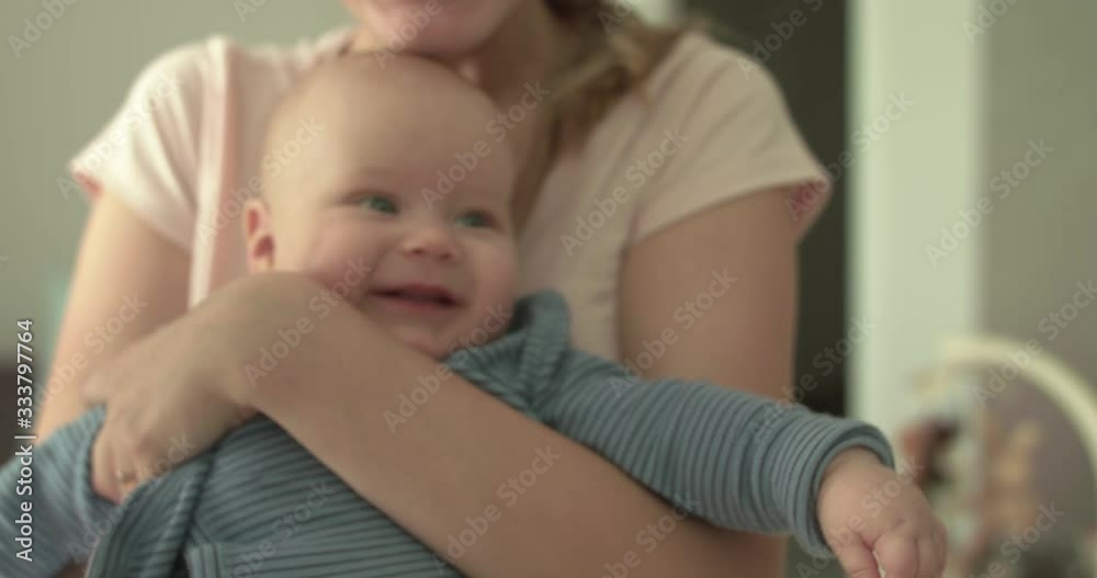 Cutie baby smiling and moving arms on mother's hands Cutie baby smiling and moving arms on mother's hands