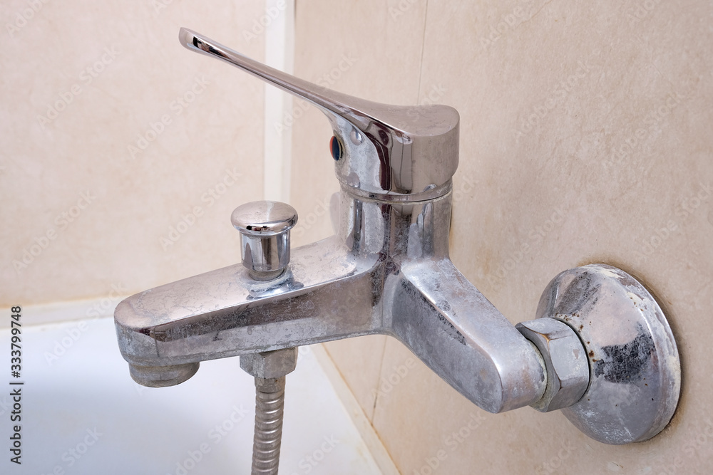 Dirty calcified shower mixer tap, faucet with limescale on it, close up Dirty calcified shower mixer tap, faucet with limescale on it, close up