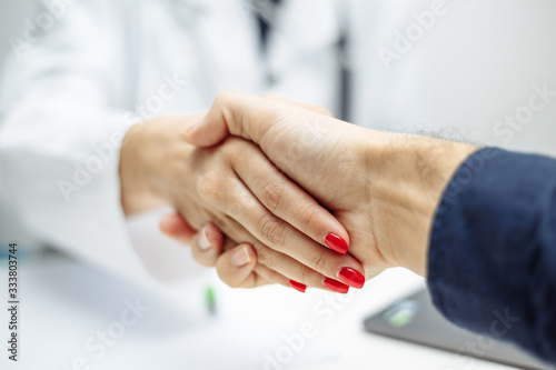 Closeup of a female doctor s and patient s hands. Discussing treatment with a patient and handshake after finding a solution and agreement. Coronavirus test and prevention concept.