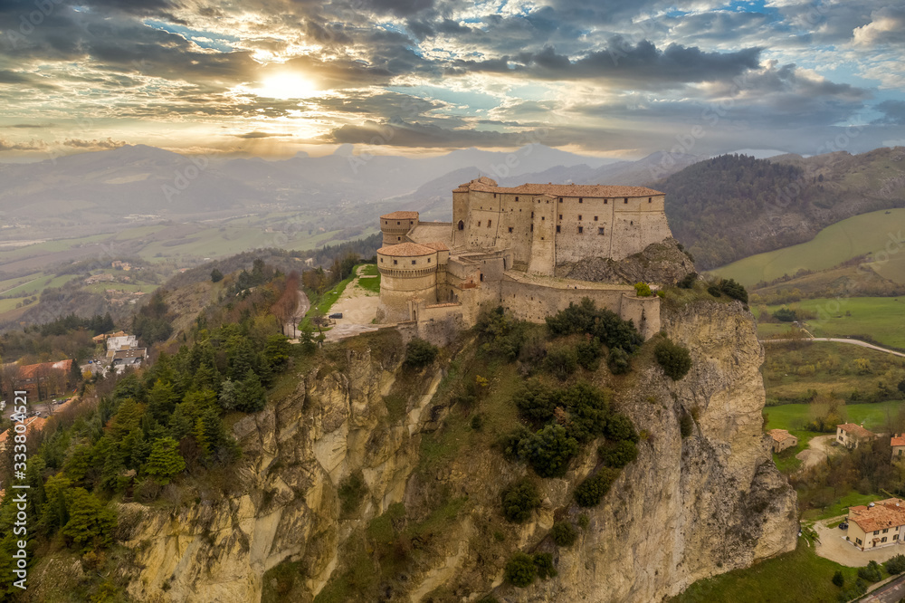 Aerial view of San Leo town and fortress used once as a prison on a rocky outcrop near the Adriatic sea resort Rimini and San Marino with Roman church