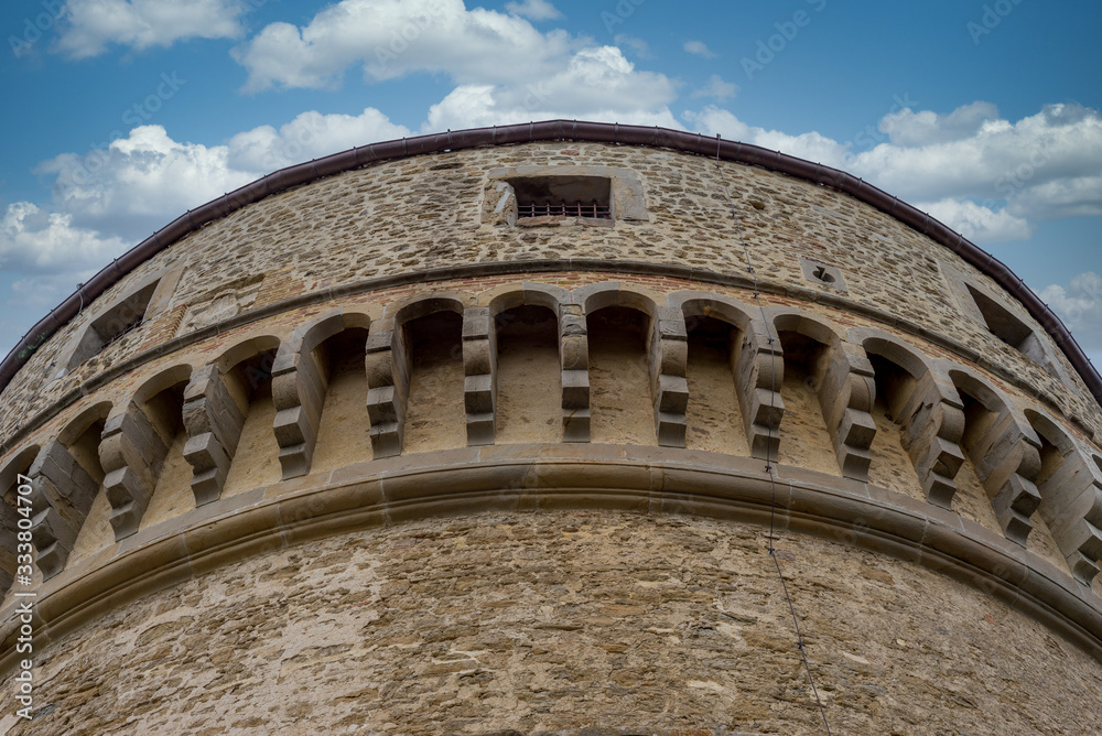 Medieval machicolation of a cannon tower supporting corbels of a battlement, through which stones or other material, such as boiling water or cooking oil, could be dropped at San Leo castle Italy