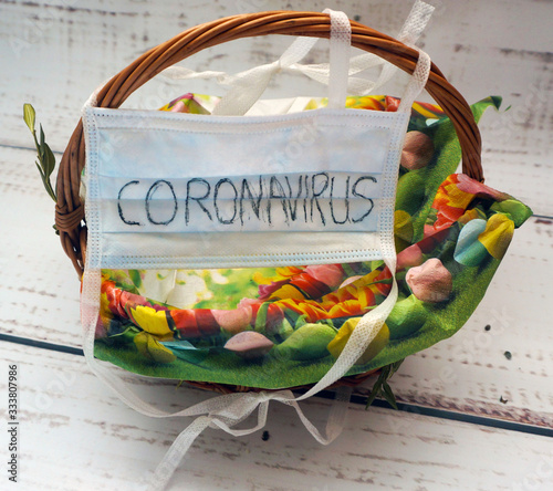 pusy Easter basket with an antiviral mask with the word coronavirus on it photo