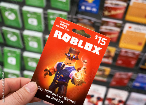 Roblox Gift Card In A Hand Over Gift Cards Background. Stock Photo | Adobe  Stock