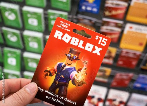 Roblox gift card in a hand over gift cards background. Stock Photo