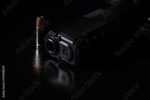 gun and bullets on black background
