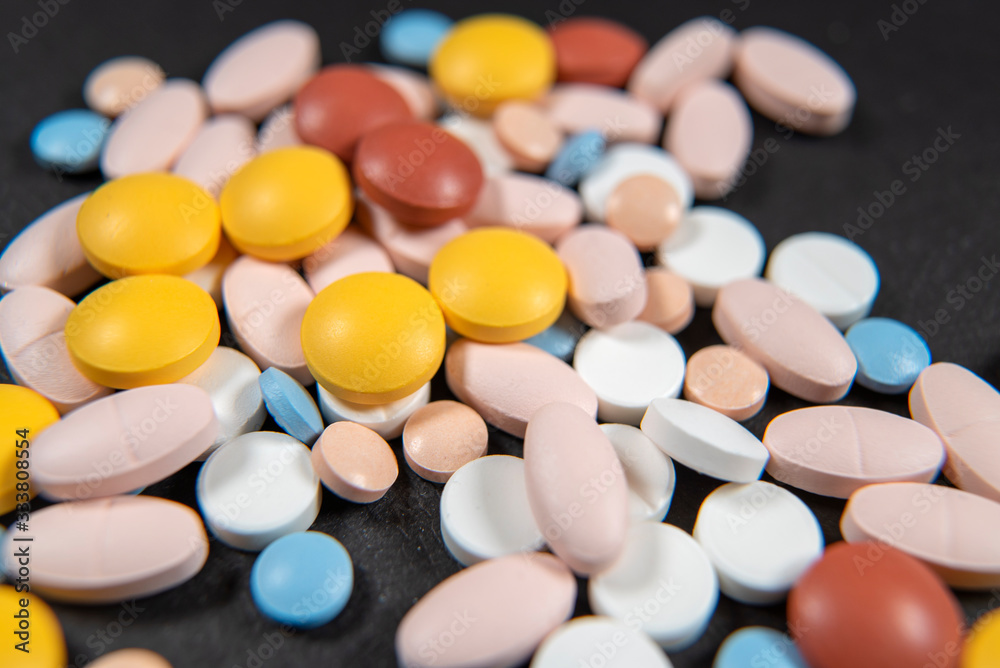 Many assorted pharmaceutical pills, tablets and capsules scattered on the black background. health care Many assorted pharmaceutical pills, tablets and capsules scattered on the black background. health care
