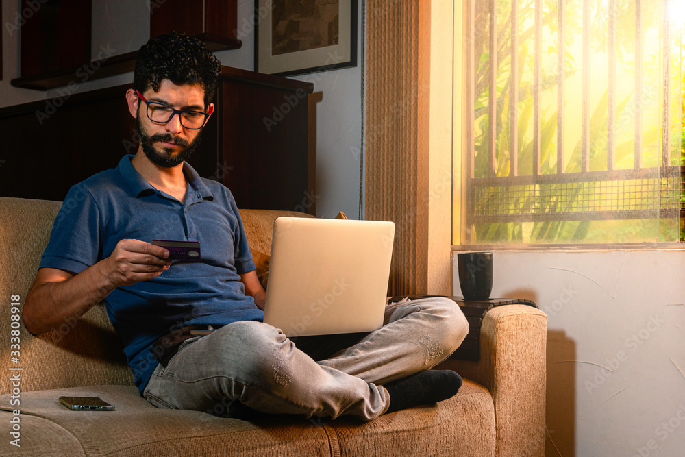 Latin making online purchase using credit card. Work at home concept. Latin making online purchase using credit card. Work at home concept.