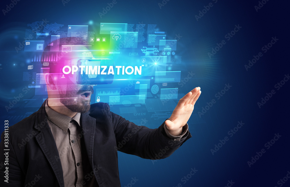 Businessman looking through Virtual Reality glasses with OPTIMIZATION inscription, innovative security concept Businessman looking through Virtual Reality glasses with OPTIMIZATION inscription, innovative security concept