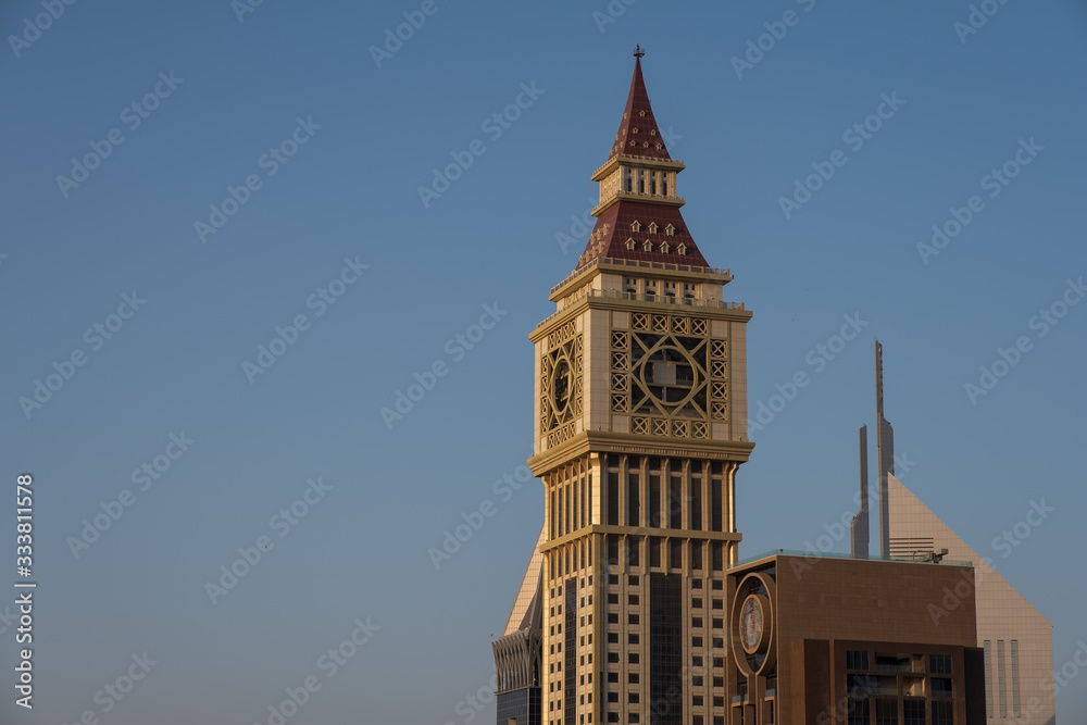 DUBAI, UAE - may 2019: Skyscrapers lining Sheikh Zayed Road. In the foreground is Al Yaqoub Tower, which was inspired by Londons famous clock tower that houses Big Ben.