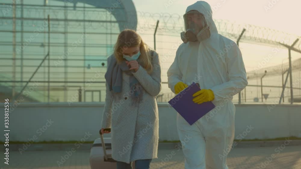 Sick woman with medical worker in protective suit screening passenger walk Covid-19 symptoms coronavirus checkpoints airports mask infection epidemic corona passengers slow motion Sick woman with medical worker in protective suit screening passenger walk Covid-19 symptoms coronavirus checkpoints airports mask infection epidemic corona passengers slow motion