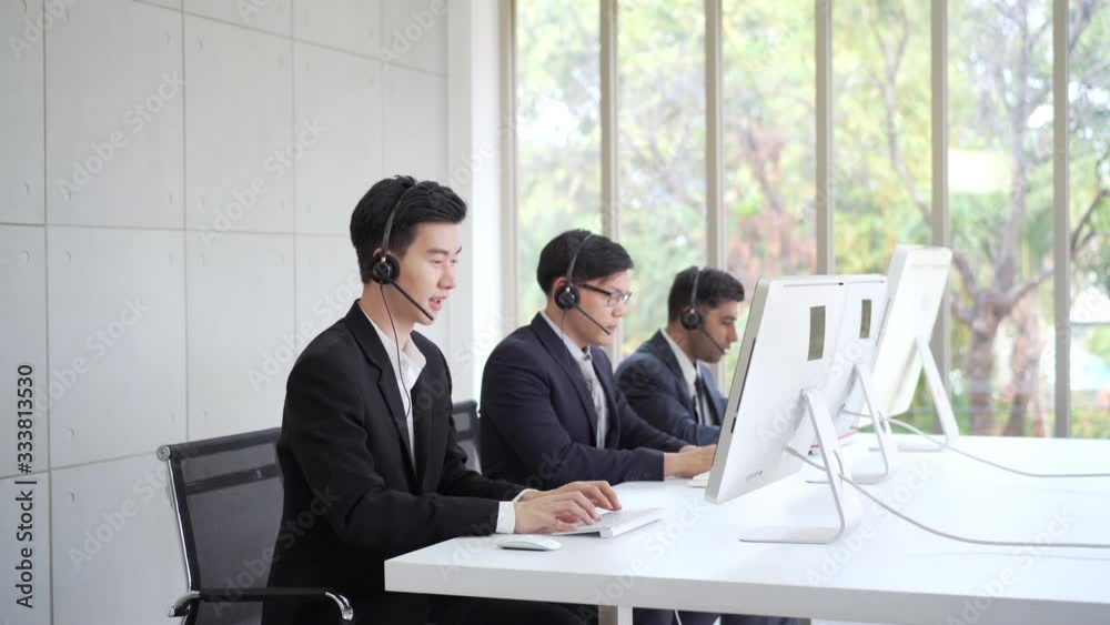Group of professional Asian man customer service agent call center with colleague speaking to client for consulting and resolving problem. Male broker telesales marketing talking on phone in office. Group of professional Asian man customer service agent call center with colleague speaking to client for consulting and resolving problem. Male broker telesales marketing talking on phone in office.