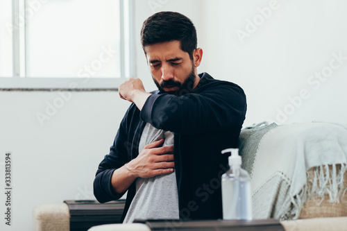 Sick man coughing in his arm joint to avoid spreading coronavirus. Covid-19.