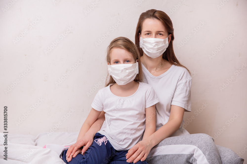 Concept of coronavirus quarantine. Mother and daughter in medical masks protect themselves from viruses and infections. Theme of health and medicine