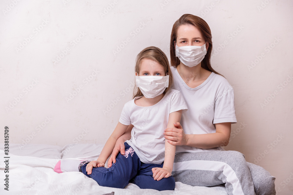 Concept of coronavirus quarantine. Mother and daughter in medical masks protect themselves from viruses and infections. Theme of health and medicine. Free space for text