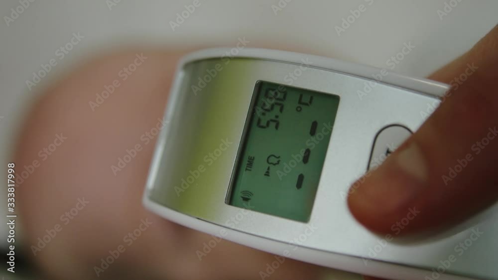 Close up on digital thermometer. Measuring temperature of newborn baby. Infant with normal temperature Close up on digital thermometer. Measuring temperature of newborn baby. Infant with normal temperature