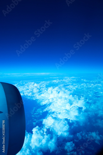 The view when looking out from the plane window that is on above the clouds © dnai