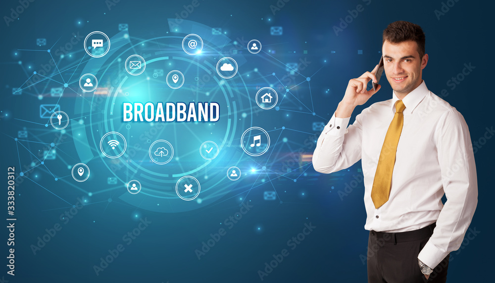 Businessman thinking in front of technology related icons and BROADBAND inscription, modern technology concept Businessman thinking in front of technology related icons and BROADBAND inscription, modern technology concept