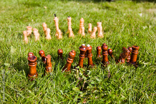 Chess pieces on the lawn on a sunny summer day. Chess game without a chessboard