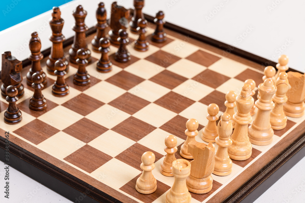 Chess board on table ready for the play with kids chairs on the background.