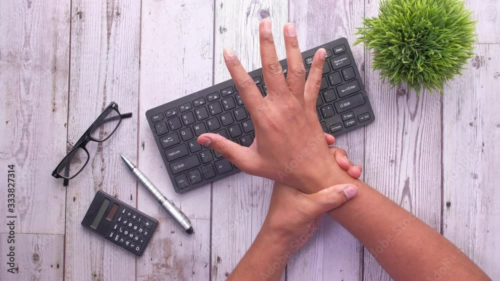 man holding her wrist pain from using computer. Office syndrome Stock