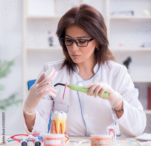 Woman dentist working on teeth implant