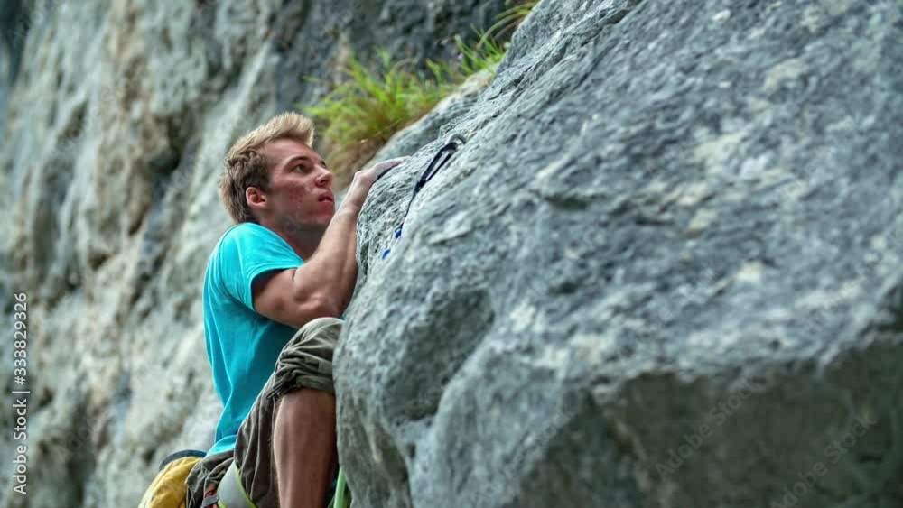 Slow motion closeup shot of a young man rock climbing on a big rock in Burjakove Peci, Slovenia Slow motion closeup shot of a young man rock climbing on a big rock in Burjakove Peci, Slovenia