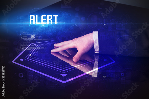 Hand touching digital table with ALERT inscription, new age security concept