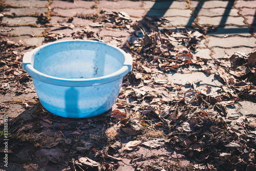 Empty blue basin for collecting dry leaves to clean the territory on spring day.