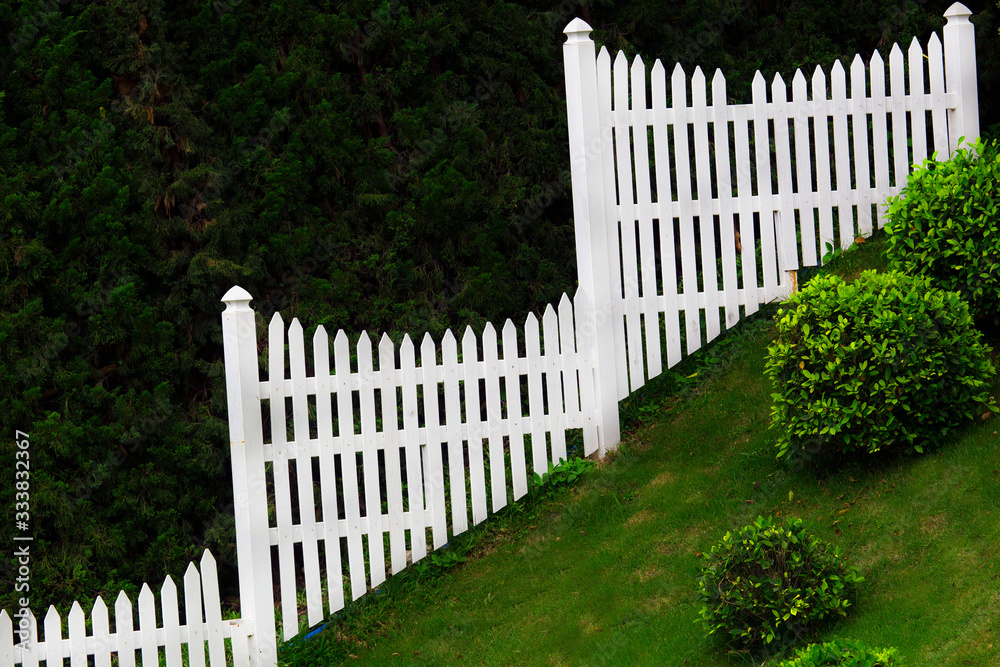 green garden on the hill with white fence