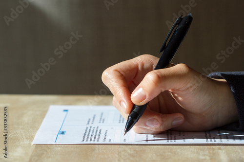 Closeup of woman's hand holding a pen filling out a census form. photo
