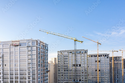 construction site with high-rise buildings and cranes on blue sky background. new residential area. aerial view