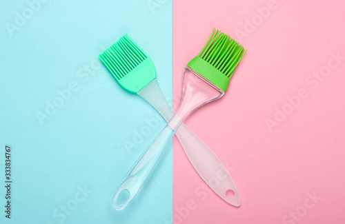 Kitchen spatula and brush on pink blue pastel background. Top view