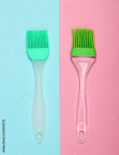 Kitchen spatula and brush on pink blue pastel background. Top view