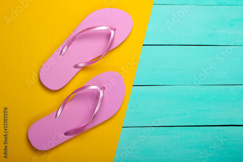 Flip flops on a yellow, blue wooden background. Top view. Beach Vacation Concept