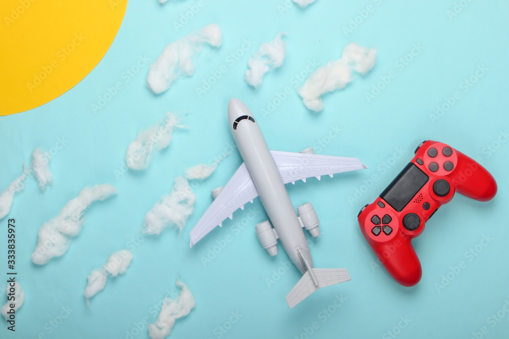 Air game. Gamepad, toy plane on a background of the sunny sky with clouds. Top view Air game. Gamepad, toy plane on a background of the sunny sky with clouds. Top view