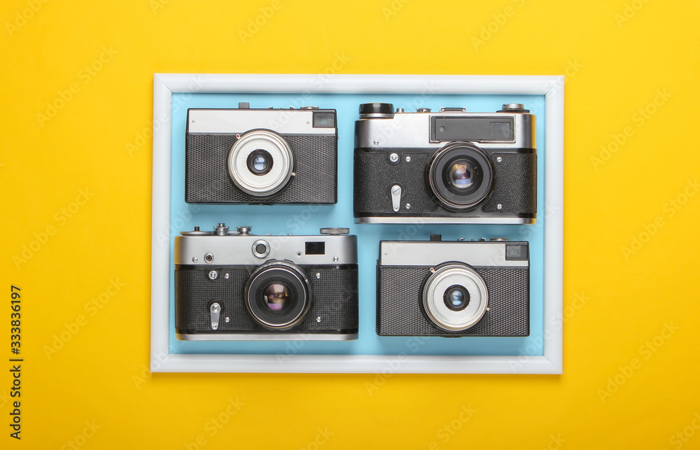 Many Retro cameras on yellow background with photo  frame. Studio shot. Creative flat lay. Top view. Minimalism