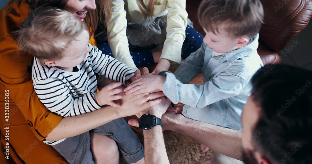 Top view happy Caucasian mom and dad with three children joining hands ...