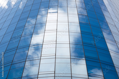 Reflection of sky in glass of office building ; abstract background